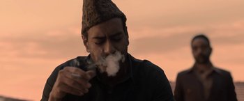 Movie still from “Gangubai Kathiawadi” (2022), directed by Sanjay Leela Bhansali – A man with a hat on smoking a cigarette; Medium shot, Low angle