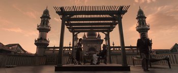 Movie still from “Gangubai Kathiawadi” (2022), directed by Sanjay Leela Bhansali – Two people sitting under a pergola at sunset; Wide shot, Low angle