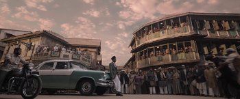 Movie still from “Gangubai Kathiawadi” (2022), directed by Sanjay Leela Bhansali – A man standing next to a car in front of a crowd of onlookers; Extreme Wide shot, Low angle