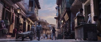 Movie still from “Gangubai Kathiawadi” (2022), directed by Sanjay Leela Bhansali – A group of people walking down a street near buildings; Extreme Wide shot, Low angle