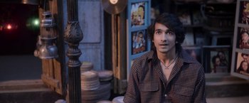 A man sitting in front of a lamp post