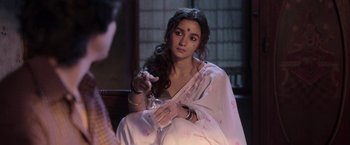 Movie still from “Gangubai Kathiawadi” (2022), directed by Sanjay Leela Bhansali – A woman in a white sari is holding a glass; Medium shot, Over the shoulder angle