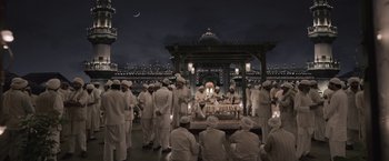 Movie still from “Gangubai Kathiawadi” (2022), directed by Sanjay Leela Bhansali – A group of men in white outfits sitting on a platform; Extreme Wide shot, High angle