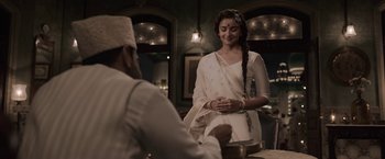 Movie still from “Gangubai Kathiawadi” (2022), directed by Sanjay Leela Bhansali – A woman standing next to a man in a white dress; Medium shot, Over the shoulder angle