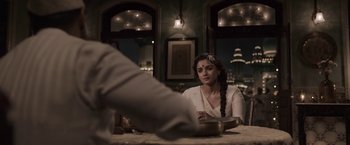 Movie still from “Gangubai Kathiawadi” (2022), directed by Sanjay Leela Bhansali – A woman sitting at a table with a plate in front of her; Medium shot, Over the shoulder angle