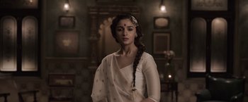Movie still from “Gangubai Kathiawadi” (2022), directed by Sanjay Leela Bhansali – A woman in a white dress with a long braid; Medium shot, Low angle
