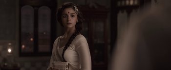 Movie still from “Gangubai Kathiawadi” (2022), directed by Sanjay Leela Bhansali – A woman in a white dress with a red flower in her hair; Close Up shot, Over the shoulder angle