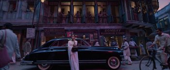 Movie still from “Gangubai Kathiawadi” (2022), directed by Sanjay Leela Bhansali – A woman standing in front of a car on a street; Wide shot, Low angle