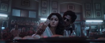 Movie still from “Gangubai Kathiawadi” (2022), directed by Sanjay Leela Bhansali – A woman is sitting in front of a mirror while another woman holds a brush; Close Up shot, Low angle