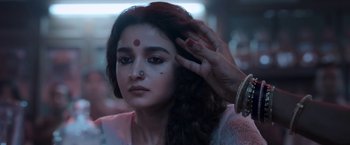 Movie still from “Gangubai Kathiawadi” (2022), directed by Sanjay Leela Bhansali – A woman is getting her face painted for a festival; Close Up shot, Low angle