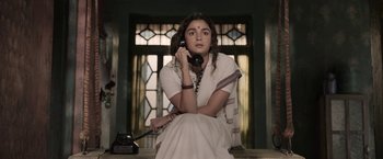 Movie still from “Gangubai Kathiawadi” (2022), directed by Sanjay Leela Bhansali – A woman sitting on the ground talking on a phone; Medium shot, Low angle