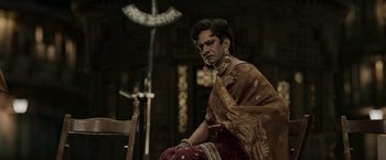Movie still from “Gangubai Kathiawadi” (2022), directed by Sanjay Leela Bhansali – A woman in a sari sitting on a chair; Medium shot, Over the shoulder angle