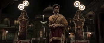 Movie still from “Gangubai Kathiawadi” (2022), directed by Sanjay Leela Bhansali – A man dressed in indian clothing standing in front of a microphone; Medium shot, Low angle