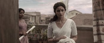Movie still from “Gangubai Kathiawadi” (2022), directed by Sanjay Leela Bhansali – A woman in a white sari is standing on a balcony; Medium shot, Low angle