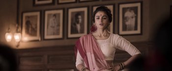 Movie still from “Gangubai Kathiawadi” (2022), directed by Sanjay Leela Bhansali – A woman in a white shirt and a pink shawl; Medium shot, Low angle