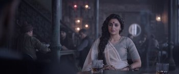 Movie still from “Gangubai Kathiawadi” (2022), directed by Sanjay Leela Bhansali – A woman sitting at a table in front of candles; Medium shot, Over the shoulder angle
