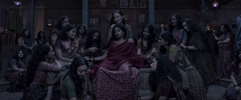 Movie still from “Gangubai Kathiawadi” (2022), directed by Sanjay Leela Bhansali – A group of women sitting around a woman in a red dress; Wide shot, High angle