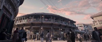 Movie still from “Gangubai Kathiawadi” (2022), directed by Sanjay Leela Bhansali – People are walking on the sidewalk in front of a building; Extreme Wide shot, Low angle