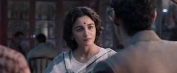 Movie still from “Gangubai Kathiawadi” (2022), directed by Sanjay Leela Bhansali – A woman in a white shirt and a white and black sari; Close Up shot, Over the shoulder angle