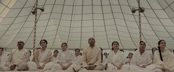 Movie still from “Gangubai Kathiawadi” (2022), directed by Sanjay Leela Bhansali – A group of people sitting in a circle under a tent; Wide shot, Low angle