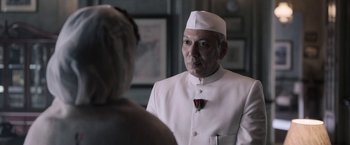 Movie still from “Gangubai Kathiawadi” (2022), directed by Sanjay Leela Bhansali – A man wearing a white suit and a rose pin; Close Up shot, Over the shoulder angle