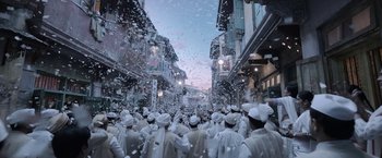 Movie still from “Gangubai Kathiawadi” (2022), directed by Sanjay Leela Bhansali – A group of people dressed in all white are standing in the middle of the street; Extreme Wide shot, High angle