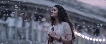 Movie still from “Gangubai Kathiawadi” (2022), directed by Sanjay Leela Bhansali – A woman with long curly hair standing in front of a building; Close Up shot, Low angle