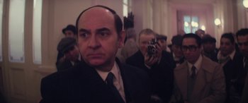 Movie still from “Neruda” (2016), directed by Pablo Larraín – A man in a suit and tie taking a picture of himself; Close Up shot, Over the shoulder angle