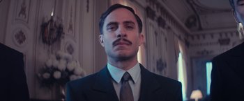 Movie still from “Neruda” (2016), directed by Pablo Larraín – A man in a suit and tie with a goatee; Close Up shot, Low angle