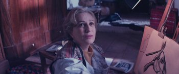 Movie still from “Neruda” (2016), directed by Pablo Larraín – A woman sitting in a chair looking at the camera; Close Up shot, High angle