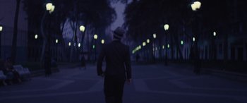 Movie still from “Neruda” (2016), directed by Pablo Larraín – A man in a suit and hat walking down a street; Wide shot, Low angle
