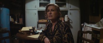 Movie still from “Neruda” (2016), directed by Pablo Larraín – A woman is sitting at a kitchen counter; Close Up shot, High angle