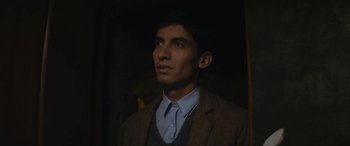 Movie still from “Neruda” (2016), directed by Pablo Larraín – A man in a suit and tie looking to his left; Close Up shot, Low angle