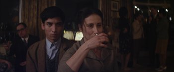 Movie still from “Neruda” (2016), directed by Pablo Larraín – A man and a woman are drinking from a cup; Close Up shot, Over the shoulder angle