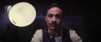 Movie still from “Neruda” (2016), directed by Pablo Larraín – A person wearing a vest and a tie; Close Up shot, Low angle