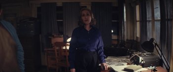 Movie still from “Neruda” (2016), directed by Pablo Larraín – A woman standing in front of a dining room table; Medium shot, High angle