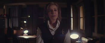 Movie still from “Neruda” (2016), directed by Pablo Larraín – A woman wearing a white shirt and a black vest; Close Up shot, Low angle