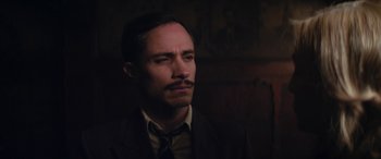 Movie still from “Neruda” (2016), directed by Pablo Larraín – A man in a suit and tie looking up; Close Up shot, Low angle