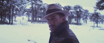Movie still from “Neruda” (2016), directed by Pablo Larraín – A man wearing a hat in the snow; Close Up shot, Low angle