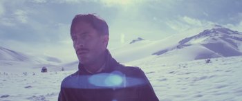 Movie still from “Neruda” (2016), directed by Pablo Larraín – A man standing on top of a snow covered slope; Close Up shot, Low angle