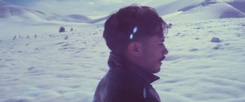 Movie still from “Neruda” (2016), directed by Pablo Larraín – A man with a beard and a jacket in the middle of a snowy field; Close Up shot, High angle