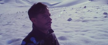 Movie still from “Neruda” (2016), directed by Pablo Larraín – A person standing in the snow; Close Up shot, High angle