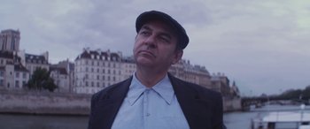 Movie still from “Neruda” (2016), directed by Pablo Larraín – A man wearing a hat and a jacket looking to his left; Close Up shot, Low angle