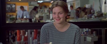 Movie still from “Never Been Kissed” (1999), directed by Raja Gosnell – A young woman smiles for the camera in an office; Close Up shot, Over the shoulder angle