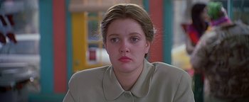 Movie still from “Never Been Kissed” (1999), directed by Raja Gosnell – A young woman with long brown hair wearing a tan shirt; Close Up shot, Over the shoulder angle