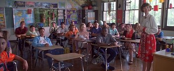 Movie still from “Never Been Kissed” (1999), directed by Raja Gosnell – A group of people sitting at desks in a classroom; Wide shot, High angle