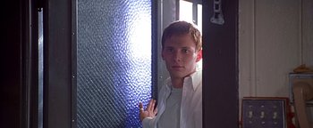 Movie still from “Never Been Kissed” (1999), directed by Raja Gosnell – A young man standing in front of a glass wall; Close Up shot, Low angle