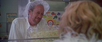 Movie still from “Never Been Kissed” (1999), directed by Raja Gosnell – A man wearing a chef's hat in front of a bowl of food; Close Up shot, Over the shoulder angle