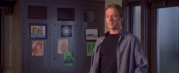 Movie still from “Never Been Kissed” (1999), directed by Raja Gosnell – A man standing in front of a door in a room; Medium shot, Over the shoulder angle