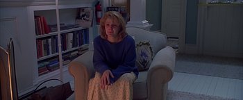 Movie still from “Never Been Kissed” (1999), directed by Raja Gosnell – A woman sitting on a chair in a living room; Medium shot, High angle